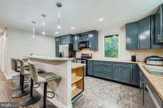a kitchen with kitchen island granite countertop wooden cabinets and a stove top oven