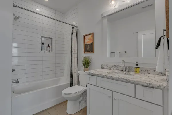 a bathroom with a granite countertop sink toilet and shower