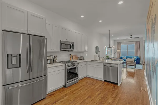 a kitchen with white cabinets stainless steel appliances and sink