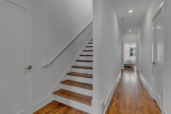 a view of a hallway with wooden floor and entryway