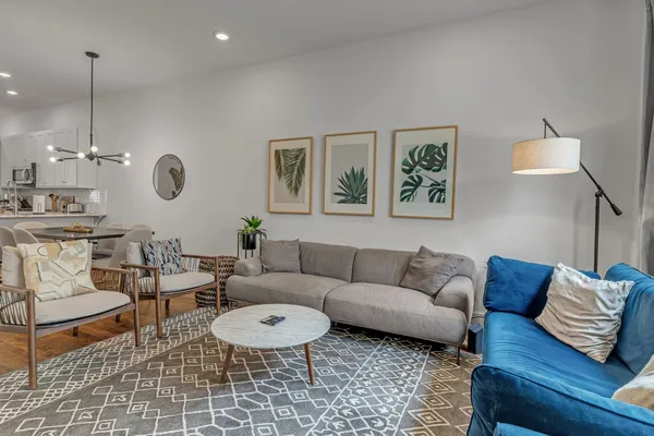 a living room with furniture a rug and a wall painting