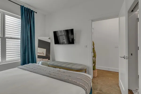 a bedroom with a bed and a flat screen tv