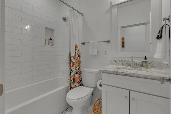a bathroom with a granite countertop sink toilet and shower