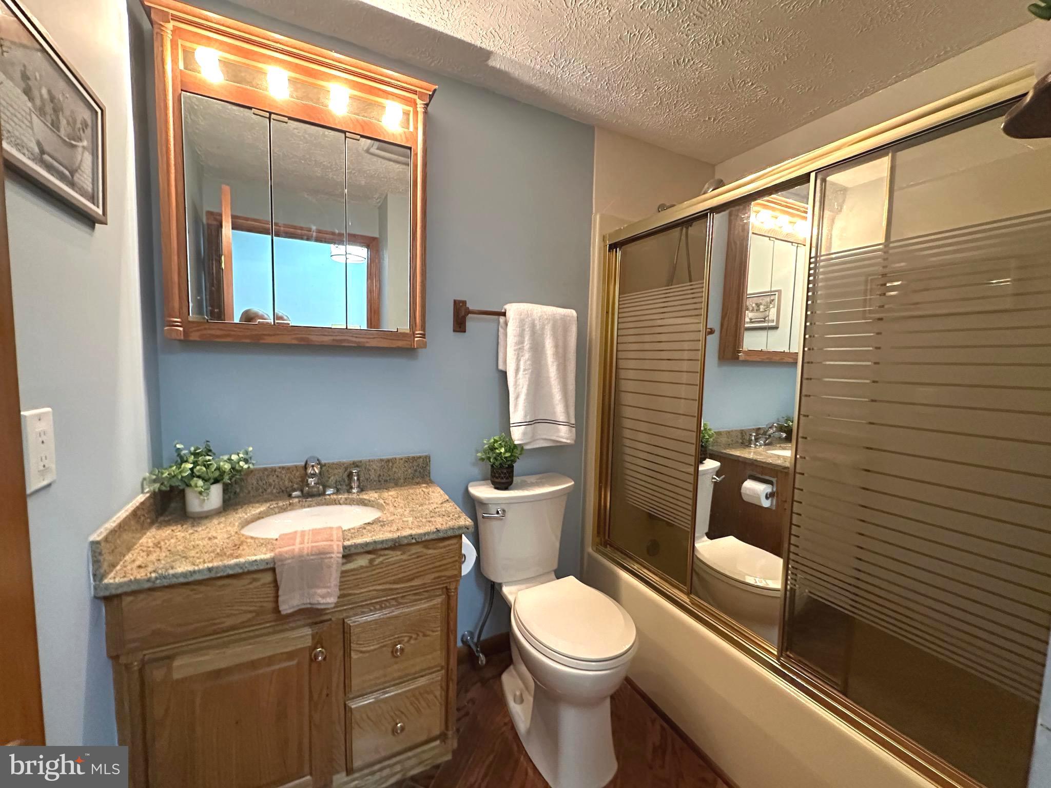 13 Cinder Road Lutherville-Timonium, MD 21093 - Photo 11 of 28 a bathroom with a granite countertop toilet sink and mirror