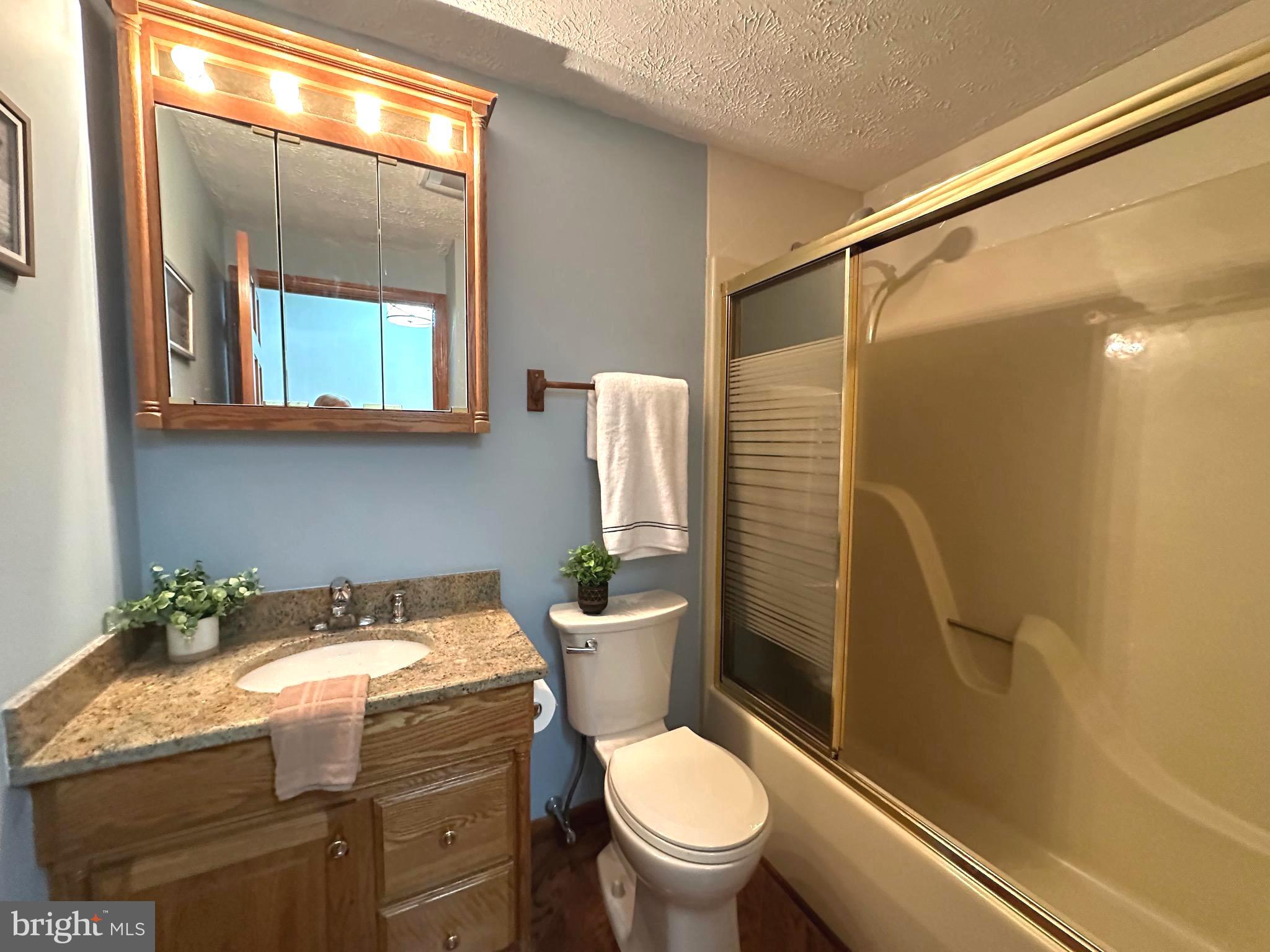 13 Cinder Road Lutherville-Timonium, MD 21093 - Photo 12 of 28 a bathroom with a granite countertop toilet sink and mirror