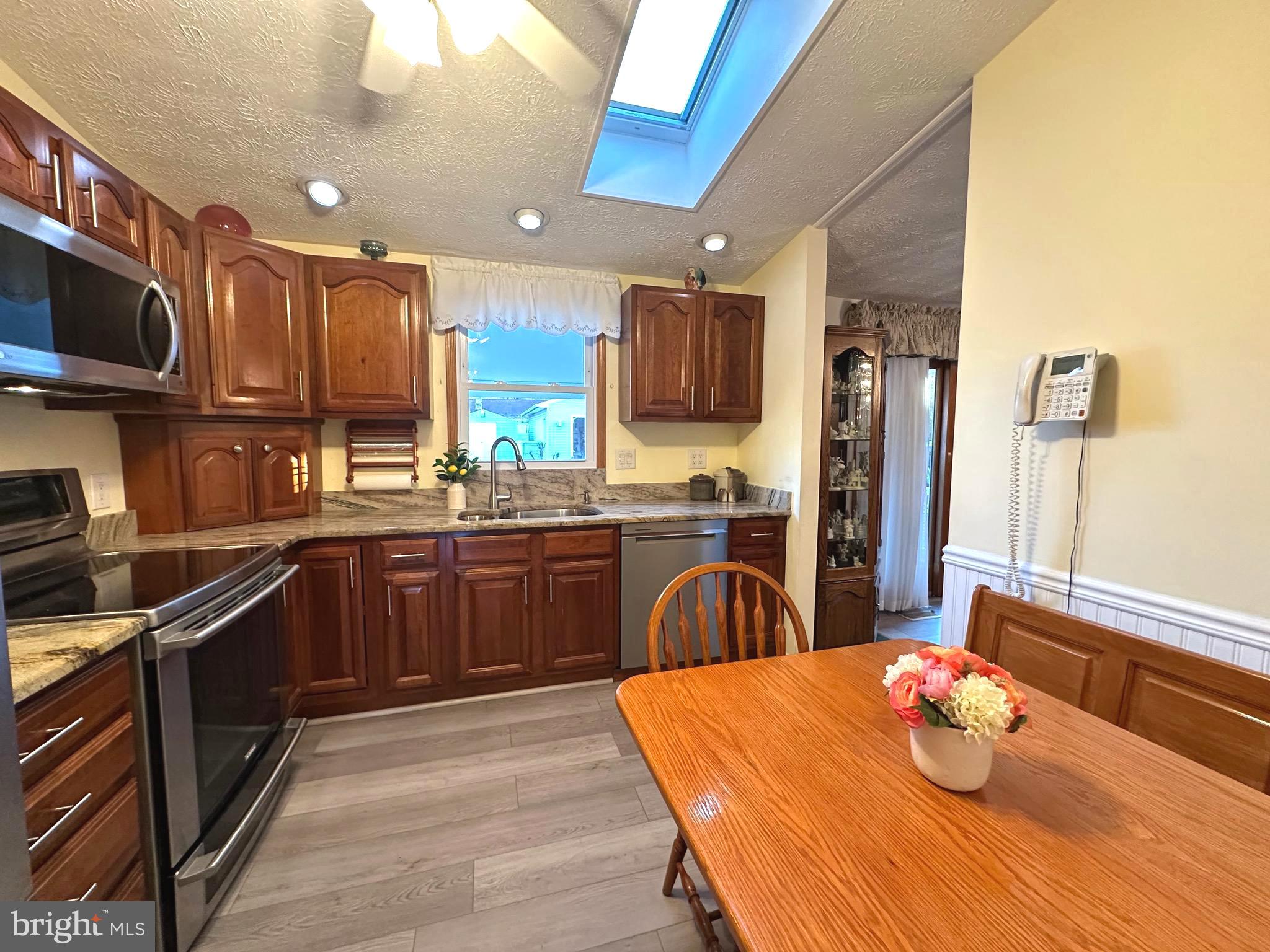 13 Cinder Road Lutherville-Timonium, MD 21093 - Photo 3 of 28 a kitchen with stainless steel appliances kitchen island granite countertop a sink refrigerator and microwave