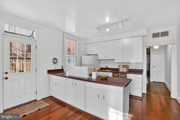 a kitchen with a sink a stove cabinets and wooden floor