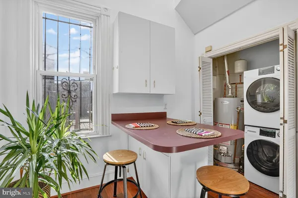 a view of a kitchen area with furniture and wooden floor
