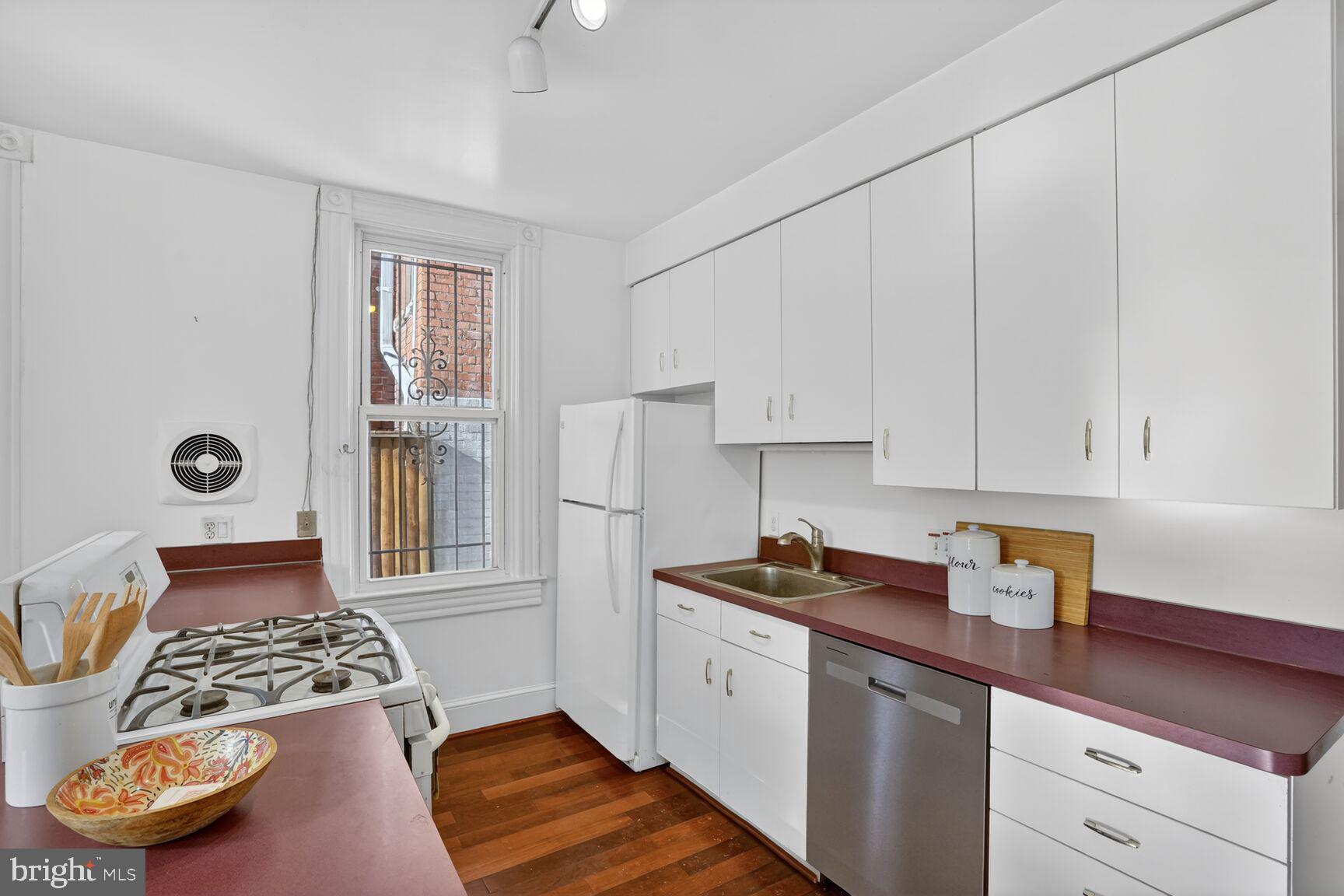 1634 R Street Northwest Washington, DC 20009 - Photo 15 of 30 a kitchen with stainless steel appliances granite countertop a sink stove and cabinets