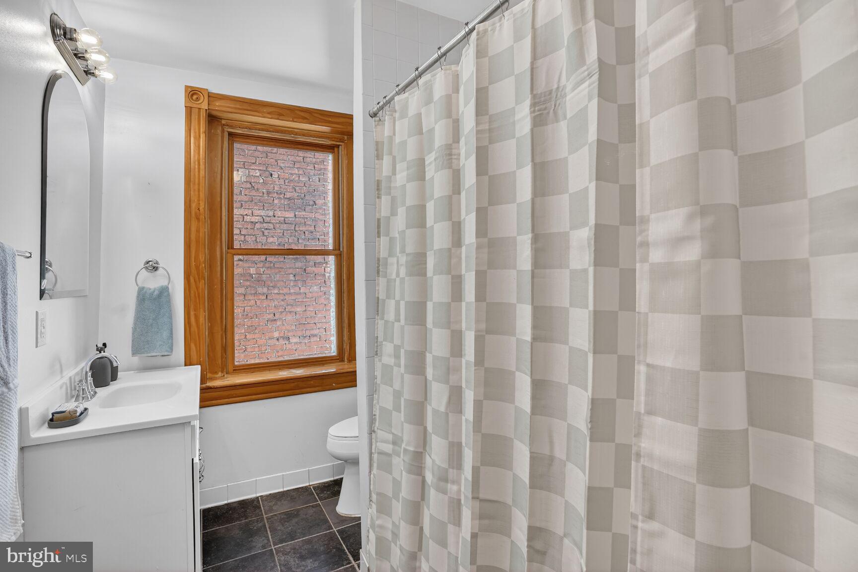 1634 R Street Northwest Washington, DC 20009 - Photo 21 of 30 a bathroom with a shower curtain and a sink