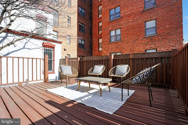 a view of a brick building with lounge chairs on a patio