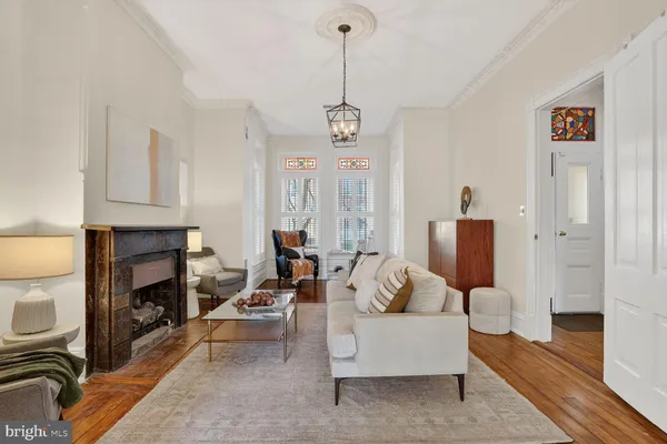 a living room with furniture a fireplace and a chandelier