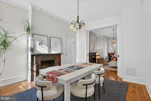 a dining room with furniture a fireplace and wooden floor