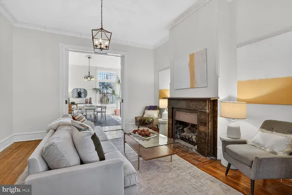 a living room with furniture a fireplace and a chandelier