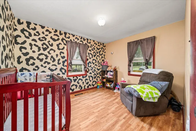 a large kitchen with stainless steel appliances wooden floor and a large window