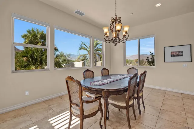a dining room with furniture a large window and a chandelier