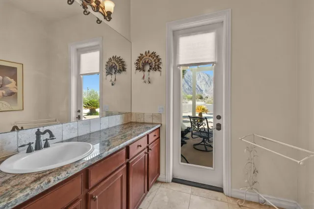 a bathroom with a granite countertop sink a mirror and a window