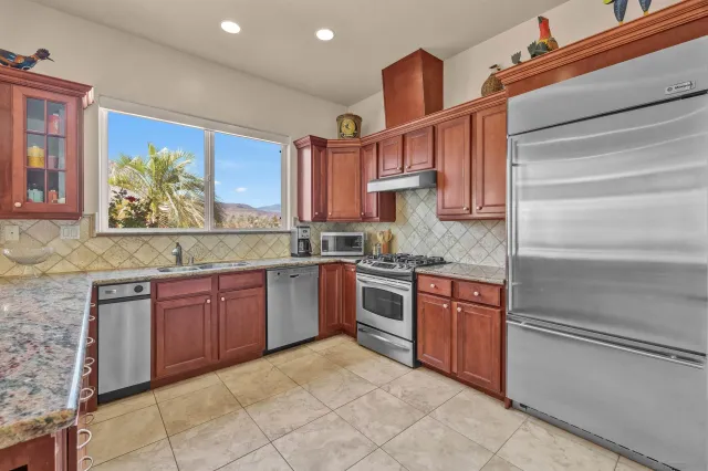 a kitchen with stainless steel appliances granite countertop a stove sink and cabinets
