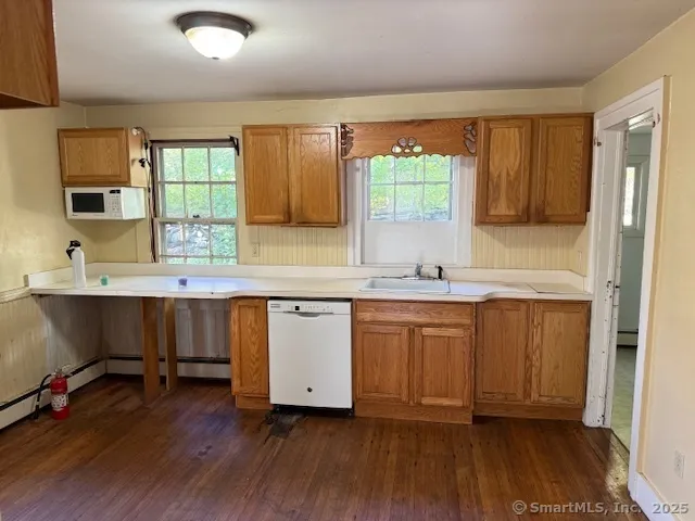 a kitchen with granite countertop wooden floors a sink and a window