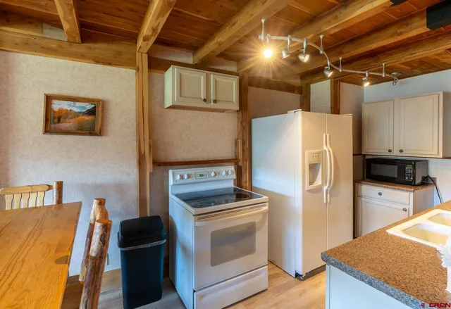 a kitchen with stainless steel appliances granite countertop a refrigerator and a stove