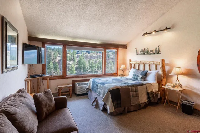 a bedroom with furniture and a large window