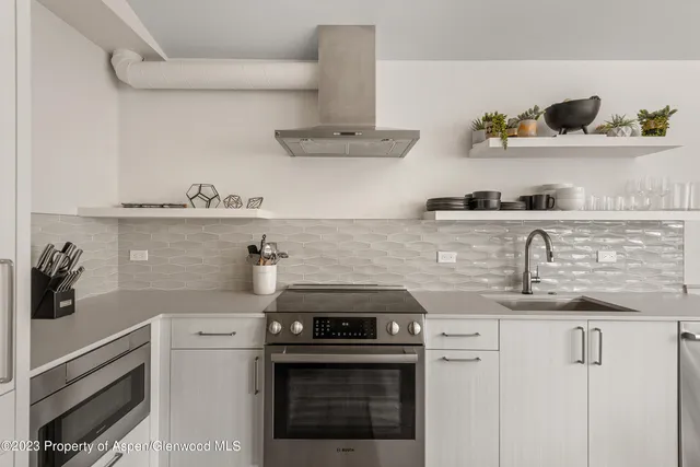a kitchen with stainless steel appliances granite countertop a stove and white cabinets