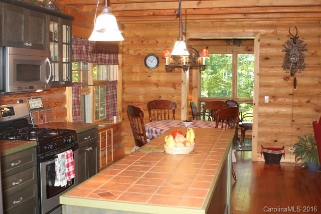 804 Battle Branch Road Bryson City, NC 28713 - Photo 3 of 23 a view of a dining room with furniture a chandelier and wooden floor