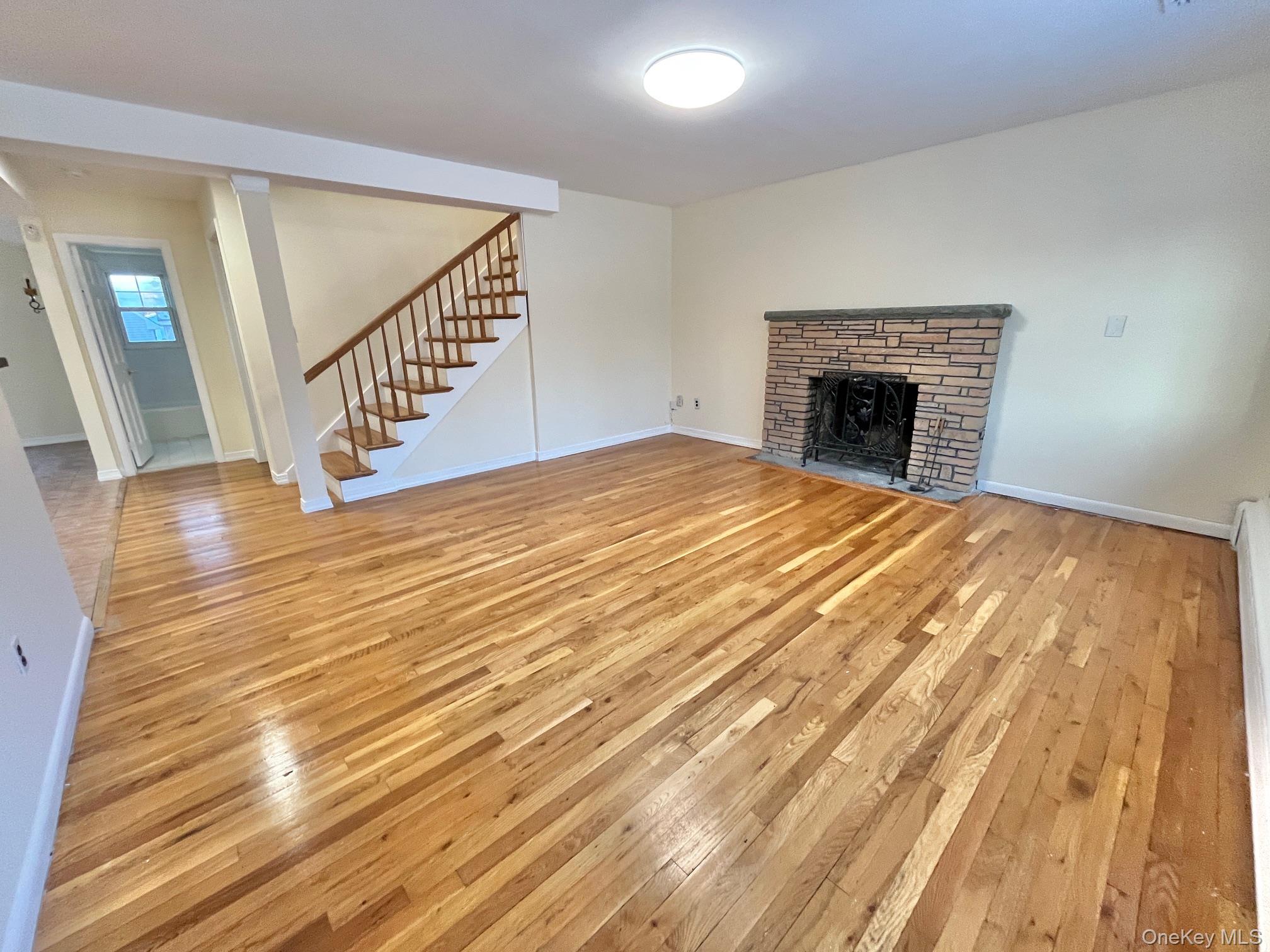 51 Emmett Terrace, Unit 1 New Rochelle, NY 10805 - Photo 1 of 23 a view of empty room with wooden floor and fireplace