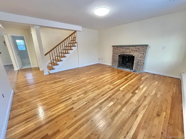 a view of empty room with wooden floor and fireplace