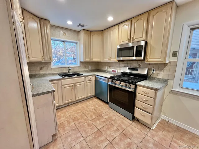 a kitchen with stainless steel appliances granite countertop a stove a sink and a refrigerator
