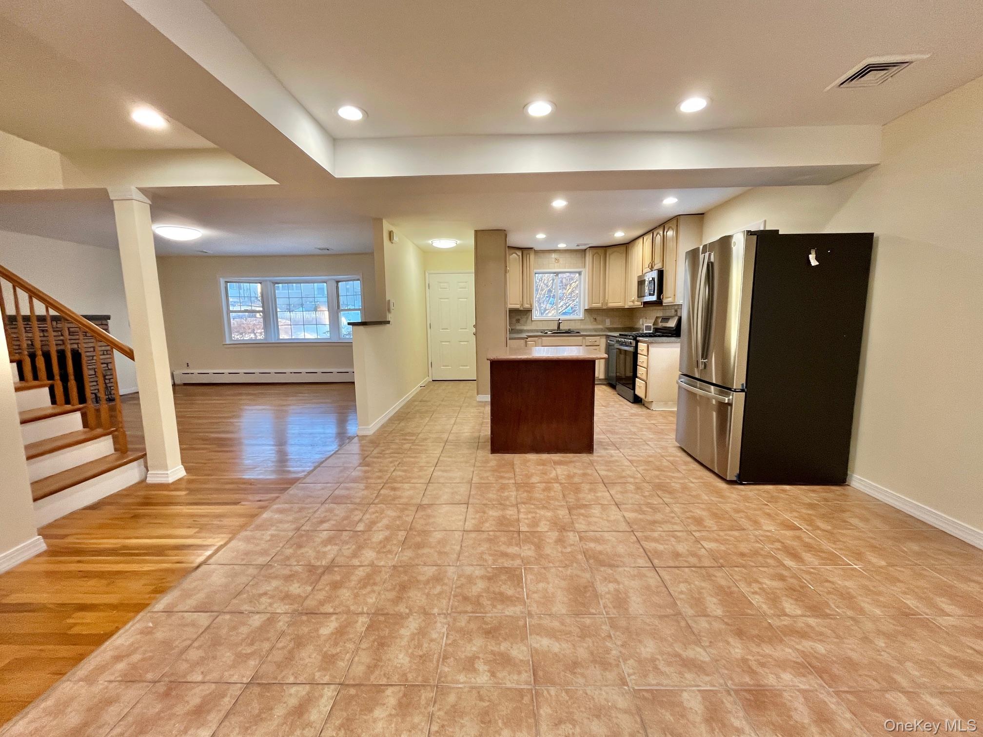 51 Emmett Terrace, Unit 1 New Rochelle, NY 10805 - Photo 7 of 23 a open kitchen with stainless steel appliances kitchen island granite countertop a refrigerator and a sink