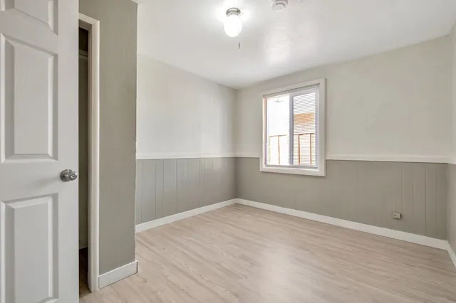 a view of empty room with wooden floor