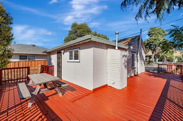 a balcony with wooden floor and potted plants