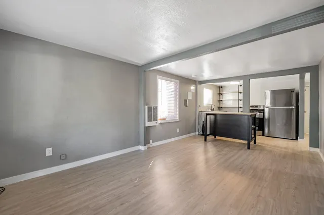 a workspace with wooden floor and a kitchen