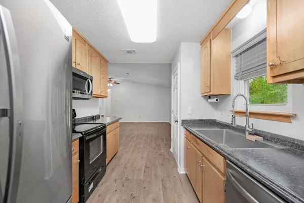 a kitchen with stainless steel appliances granite countertop a stove a refrigerator and a microwave