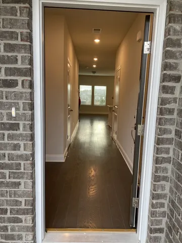 a view of a hallway with wooden floor and windows