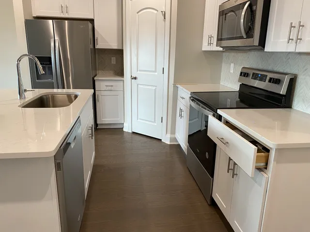 a kitchen with stainless steel appliances granite countertop white cabinets and stove