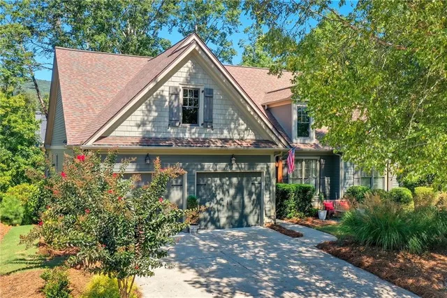 a view of a white house with large windows and a small yard
