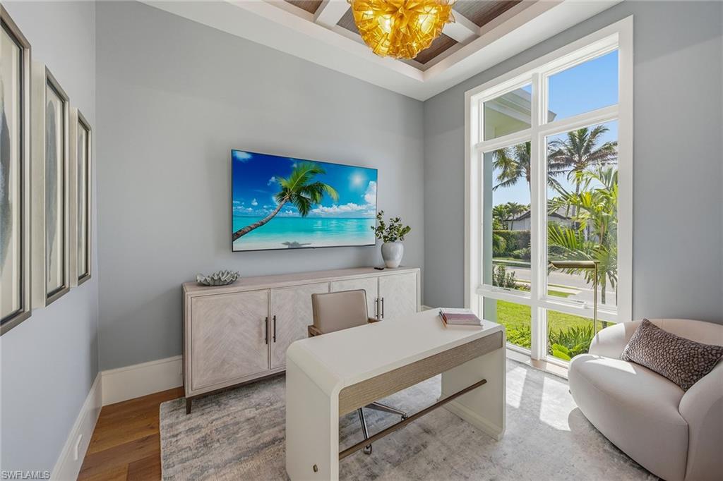 529 Neapolitan Way Naples, FL 34103 - Photo 16 of 26 a living room with furniture and a flat screen tv