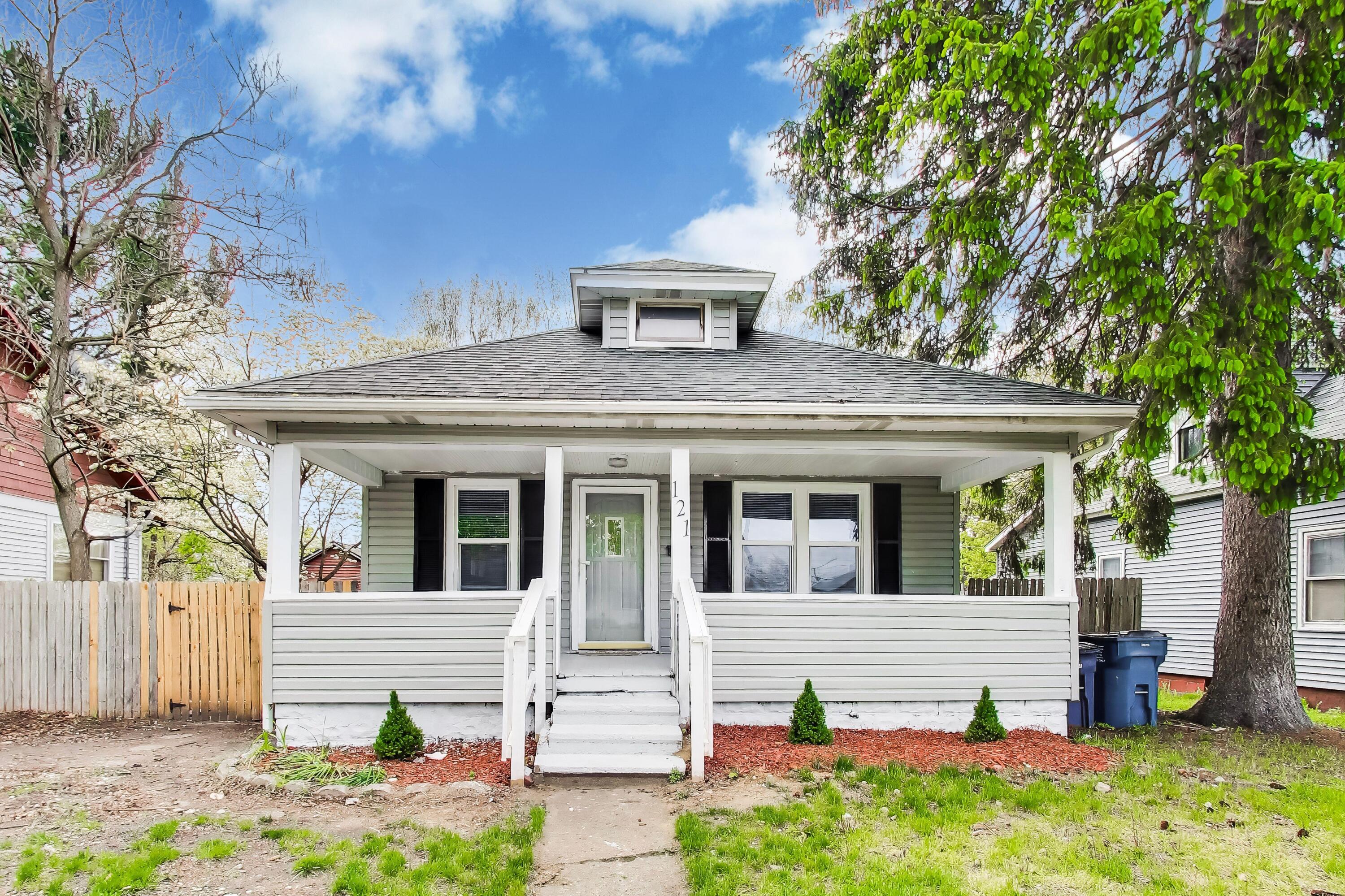 121 Faulkner Street Michigan City, IN 46360 - Photo 1 of 15 a front view of a house with a garden