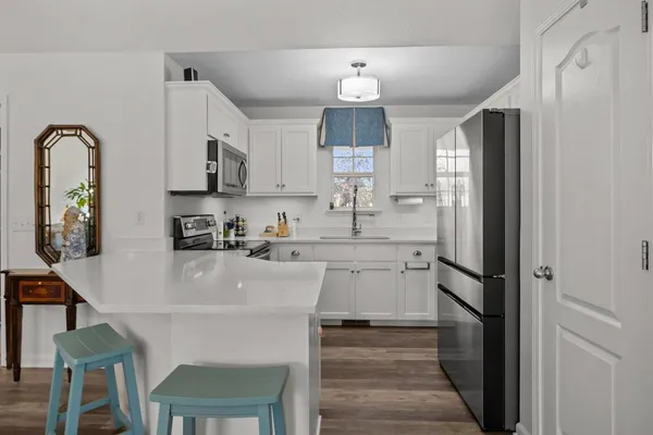 a kitchen with granite countertop white cabinets and stainless steel appliances