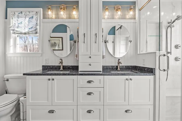 a bedroom with a beds chandelier and a window