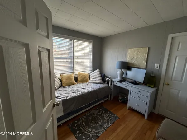 a bedroom with a bed and wooden floor