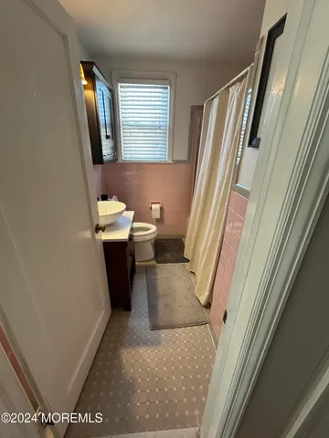 a bathroom with a sink a toilet and a mirror