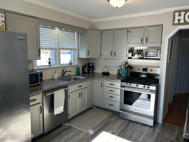 a kitchen with stainless steel appliances granite countertop a stove a sink and a refrigerator