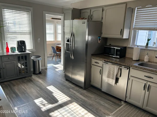 a kitchen with stainless steel appliances granite countertop a refrigerator a stove a sink and dishwasher