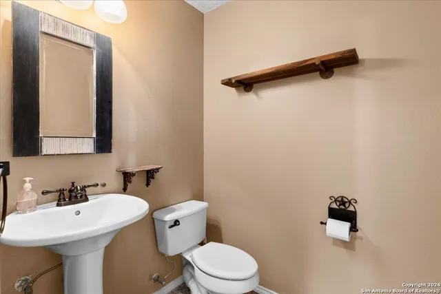 a bathroom with a sink mirror and toilet
