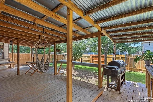 a view of a chairs and table in the patio next to a yard