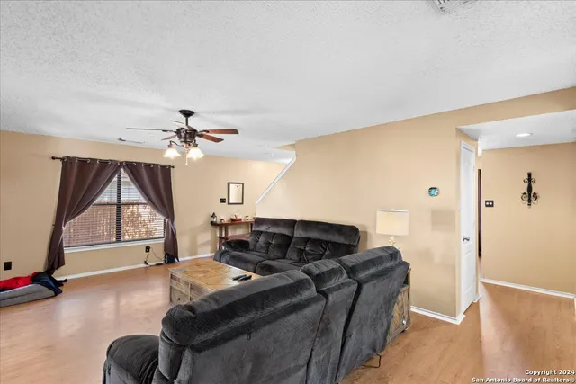 a living room with furniture a ceiling fan and a window