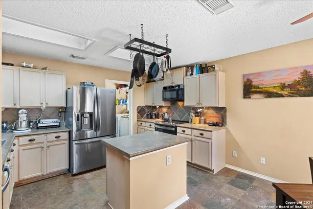 a kitchen with a sink a refrigerator and cabinets
